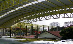 rangka kuda-kuda baja pipa, berbentuk lengkung serta menggunakan cat warna kuning