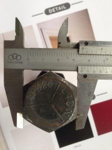 Proses pengukuran lebar kepala baut baja yang berkualitas, dengan menggunakan alat jangka sorong